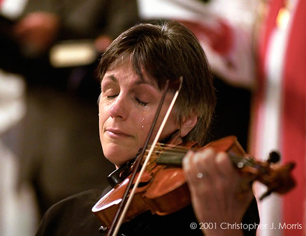 A violinista Dancy Dinovo chorando enquanto toca em homenagem às vítimas do 11 de setembro, na Christ Church Cathedral, em Vancouver, Canadá.